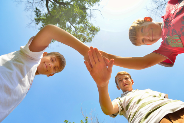 Freunde halten die Hände zusammen, Blick von unten auf eine Gruppe von Menschen, die Hände umklammert. - Foto, Bild