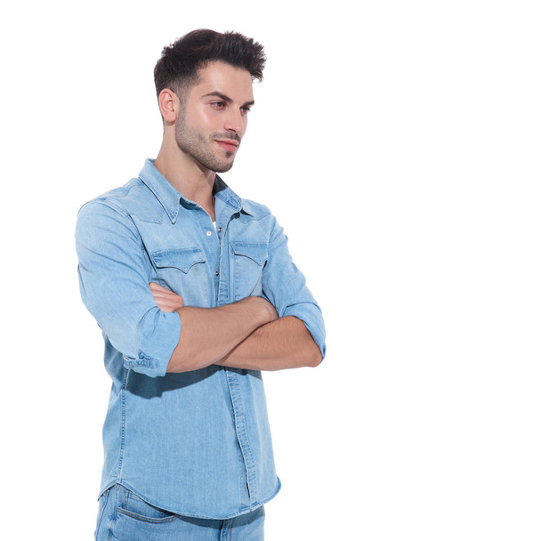 relaxed young man wearing denim and folding arms - Photo, Image