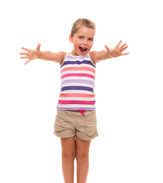 χαριτωμένο μικρό κορίτσι στέκεται πάνω σε λευκή λωρίδα τα χέρια προς τα εμπρός - Φωτογραφία, εικόνα