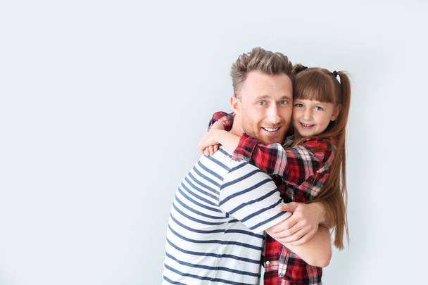 Portrait of happy father and daughter on light background - Photo, Image