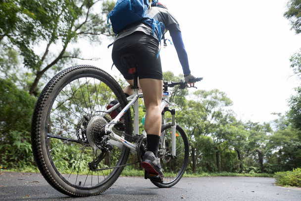 Woman cyclist riding mountain bike on tropical rainforest trail - Fotoğraf, Görsel