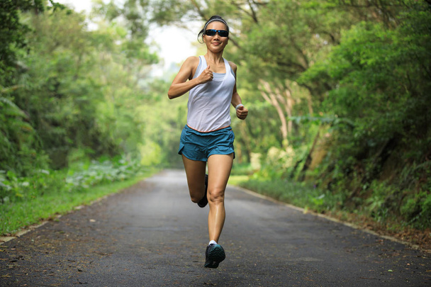 Female runner running at summer park trail . Healthy fitness woman jogging outdoors. - Foto, Imagem