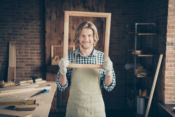 Portrait of his he nice attractive handsome blond cheerful cheery creative artisan guy artist holding in hands new smooth frame at industrial brick loft style interior workplace - Foto, Bild
