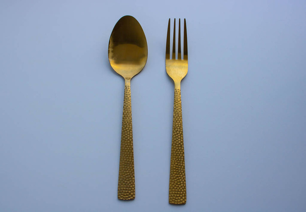 Golden spoon and fork isolated on a white background - Photo, image