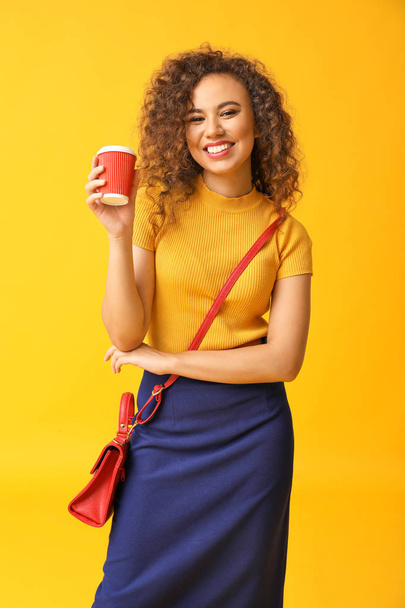 Stylish African-American woman with cup of coffee on color background - Foto, imagen