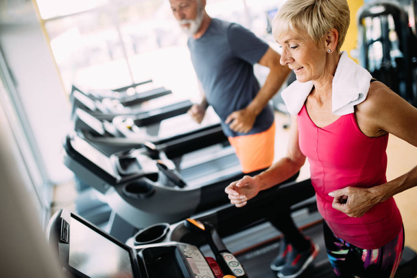 Senior fit couple exercising in gym to stay healthy - Foto, Imagem