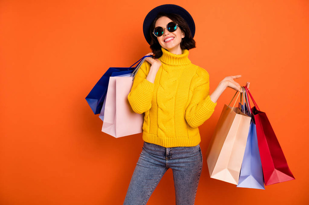 Photo of nice charming girl attractive joyful girl having just ended up shopping and being overjoyed and cheerful while isolated with orange background - 写真・画像