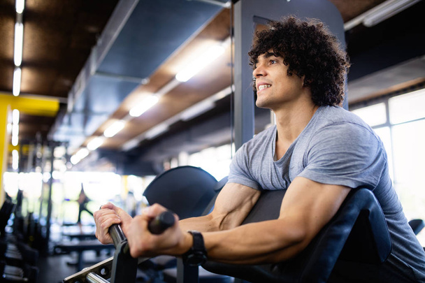 Happy fit man doing exercises in gym - Photo, Image
