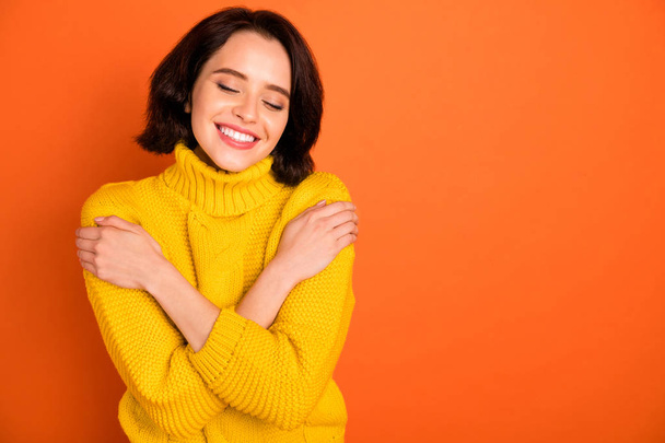 Copyspace photo of nice cute attractive cute cheerful charming pretty sweet fascinating girl pleased with her newly bought sweater while isolated with orange background - Фото, зображення