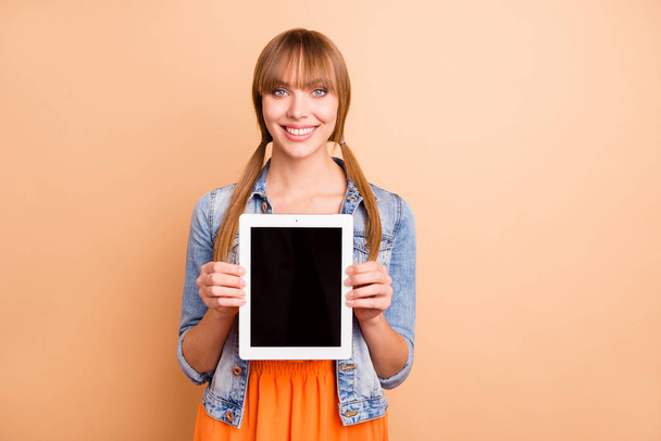 Pretty freelancer lady advising new e-reader after using wear casual outfit isolated pastel beige background - Foto, Imagen