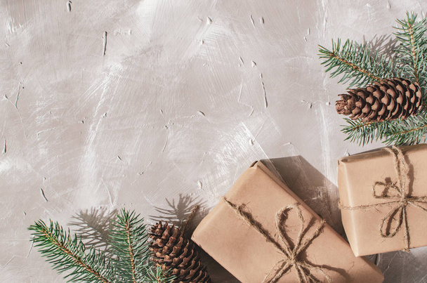 Kerst achtergrond. Geschenkdozen met een takje van een kerstboom op een grijze achtergrond - Foto, afbeelding