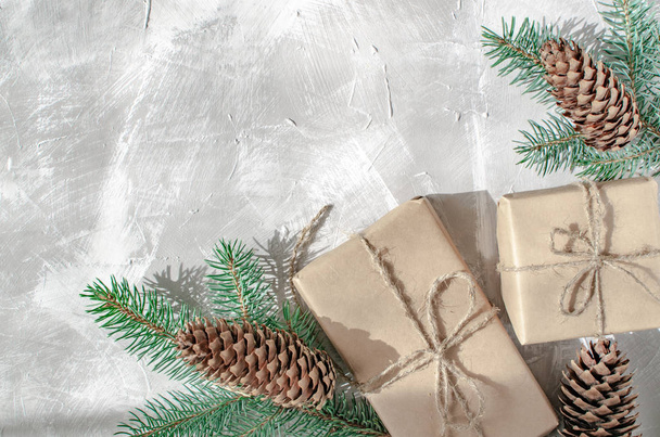 Christmas background. Gift boxes with a sprig of a Christmas tree on a gray background - Valokuva, kuva