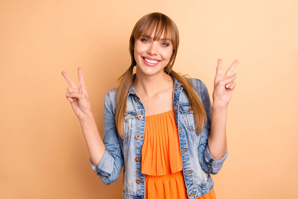 Portrait of cute lovely nice youth make v-signs have vacation holiday toothy she her good-looking dressed orange skirt dress isolated pastel beige background tails - Фото, изображение