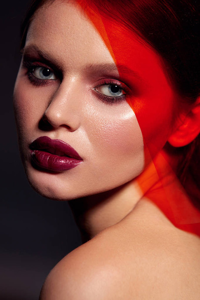 Makeup beauty. Fashion woman model with lipstick under red light - Photo, Image