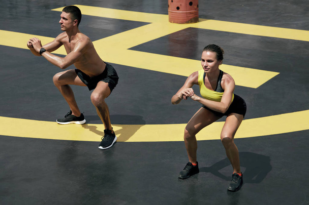 Спортивні люди займаються вправами, роблять присідання тренування на відкритому повітрі
 - Фото, зображення