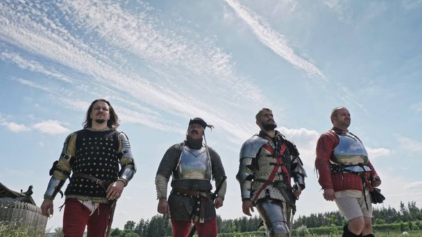 Medieval knights going against blue sky. Knights wearing traditional steel armor. - Photo, Image