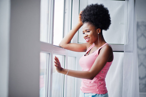 Young african american woman in pink singlet against window. Per - Photo, image
