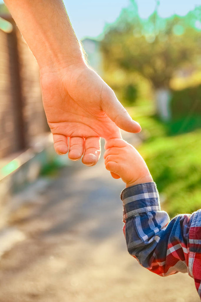 родитель, держащий руку ребенка на счастливом фоне - Фото, изображение