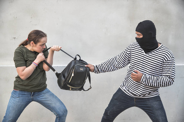 вор крадет сумку у ходячей женщины на улице с ножом в руке (концепция кражи
) - Фото, изображение