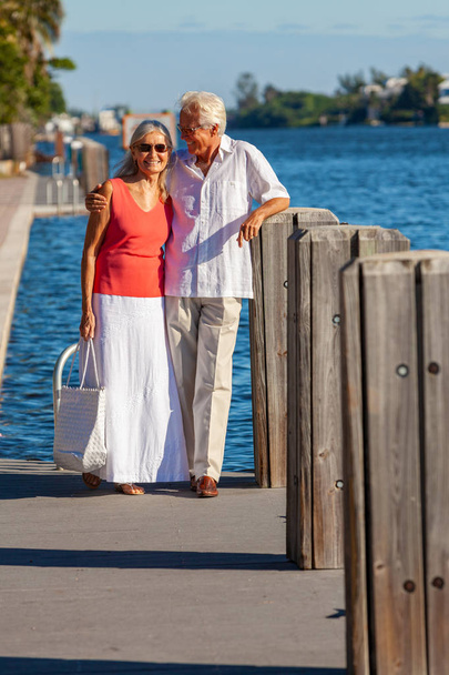 Happy Senior Couple Walking by a Tropical Sea or River - Photo, Image