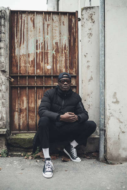 young black man sitting in the street and looking camera - Fotoğraf, Görsel