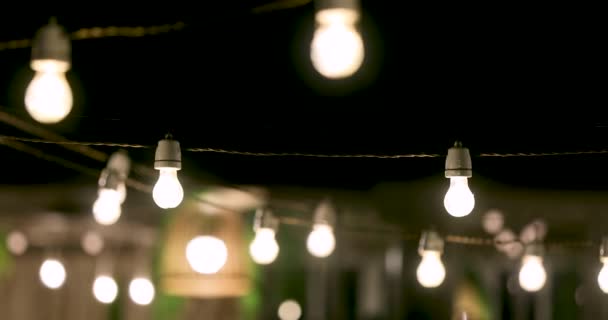 luces de cadena de fiesta al aire libre que brillan por la noche
 - Imágenes, Vídeo