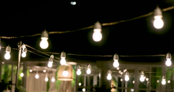 luces de cadena de fiesta al aire libre que brillan por la noche
 - Metraje, vídeo