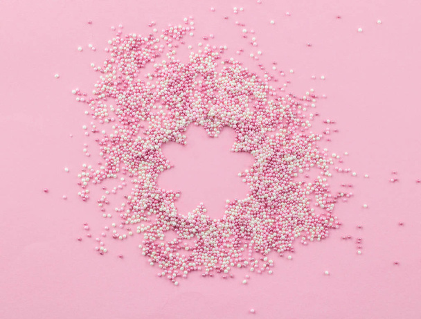 Rózsaszín és fehér, ehető pearlized Sprinkles a rózsaszín háttér-torta tetejelése Sprinkles - Fotó, kép