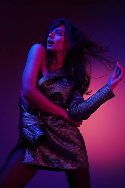Fashion woman model in fashionable dress in neon light at studio - Foto, imagen