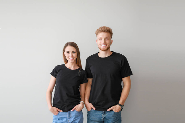 Paar in stylischen T-Shirts auf hellem Hintergrund - Foto, Bild