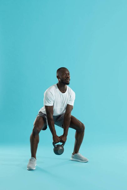 Fitness training. Sports man doing kettlebell squat workout - Fotoğraf, Görsel