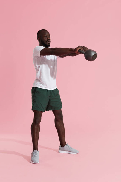 Workout. Man doing kettlebell swing exercise, sports training - Foto, Imagem