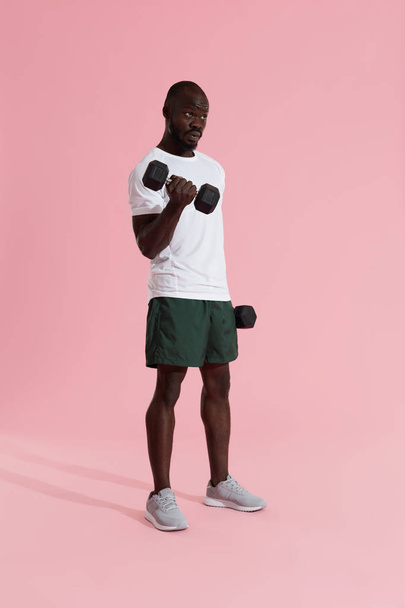 Exercise. Sports man doing dumbbell biceps workout training - Fotó, kép