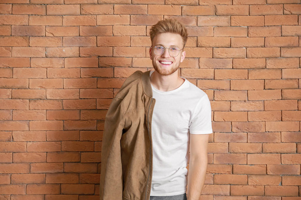 Man in stylish t-shirt against brick wall - Photo, Image