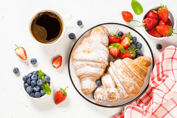 Croissant with fresh berries and cup of coffee. - Photo, Image