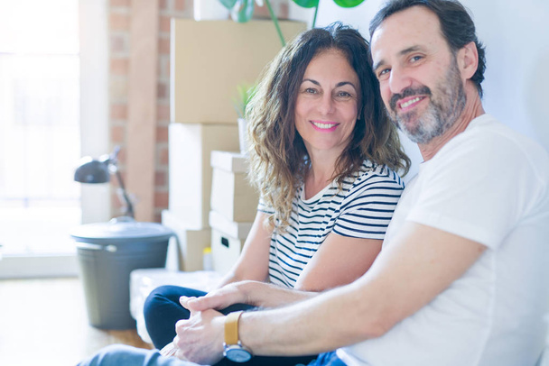 中年のシニアロマンチックなカップルは、周りの段ボール箱とアパートの床に座って、新しい家に移動するための幸せ笑顔 - 写真・画像