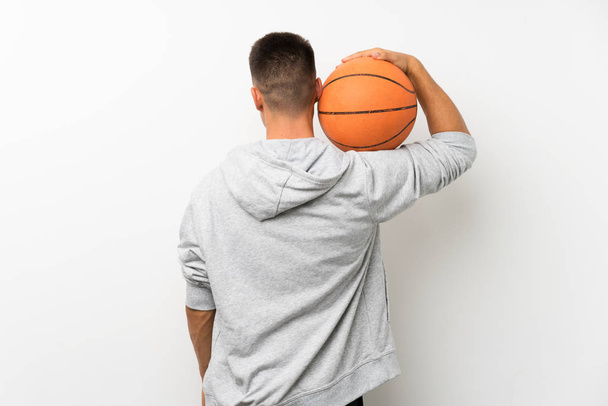 Sport man over isolated white wall with ball of basketball - Foto, Imagem