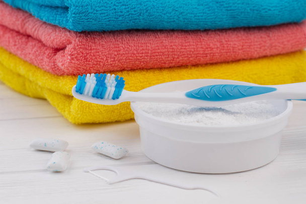 Οδοντόβουρτσα, σκόνη καθαρισμού, οδοντικό νήμα και πετσέτες. - Φωτογραφία, εικόνα