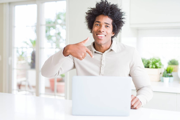 Афроамериканец, работающий на ноутбуке с неожиданным лицом, указывающим пальцем на себя
 - Фото, изображение