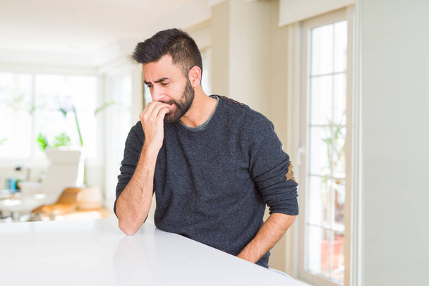 Pohledný Hispánec, který nosí doma neformální svetr, je rozstresovaný a nervózní s rukama na ústech. Úzkostná potíž. - Fotografie, Obrázek