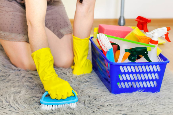 Frau in Handschuhen beim Reinigen von Kunstpelz-Rug.Housekeeping und Reinigungskonzept - Foto, Bild