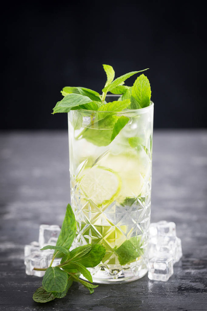 Cold drink with lime, mint and soda isolated on textured gray ta - Φωτογραφία, εικόνα