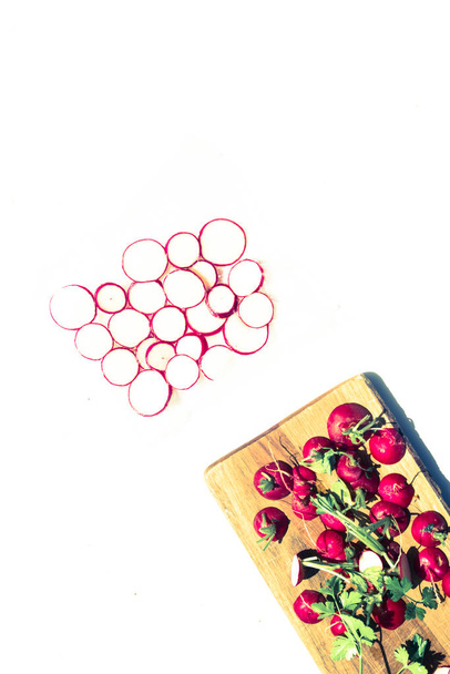 Radishes vacuum sealed on a plastic bag,on a white board sliced on a cutboard - Photo, Image