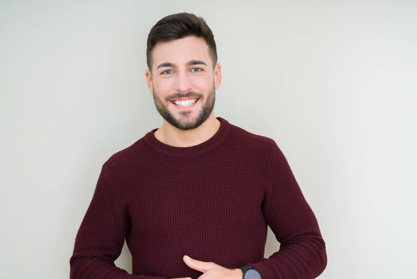 Young handsome man wearing a sweater over isolated background Hands together and fingers crossed smiling relaxed and cheerful. Success and optimistic - Photo, Image