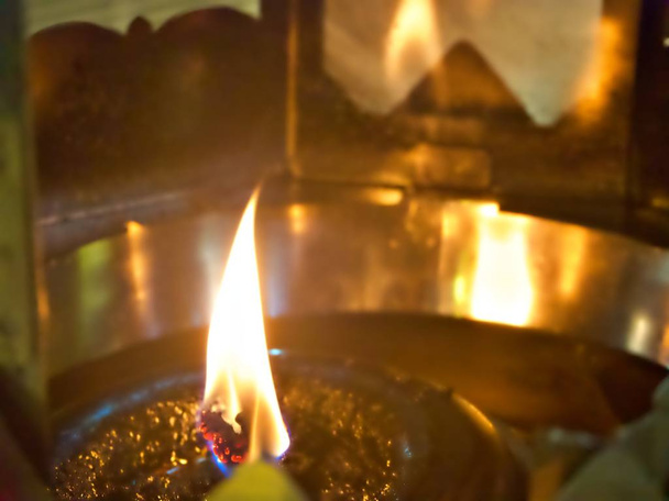 Tiro na chama que tampa sobre a lâmpada de óleo no templo budista, Tailândia
 - Foto, Imagem
