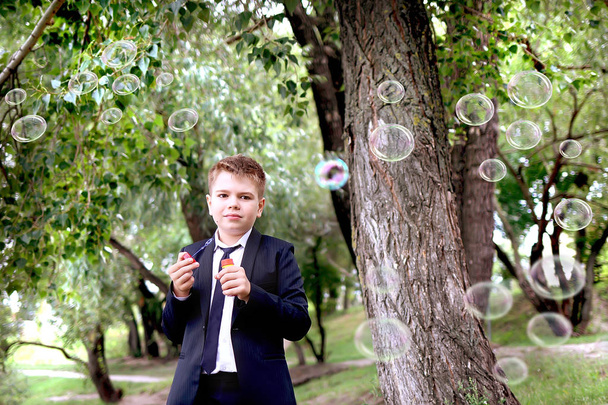 colegio chico soplando jabón burbujas al aire libre
 - Foto, Imagen