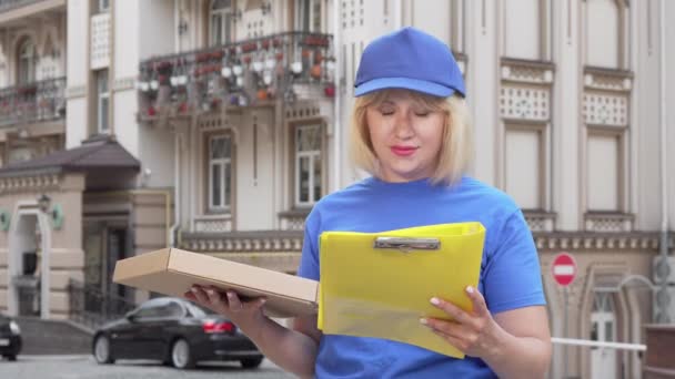 Barátságos pizza nő mosolygott a kamerába, miközben dolgozik a városban - Felvétel, videó