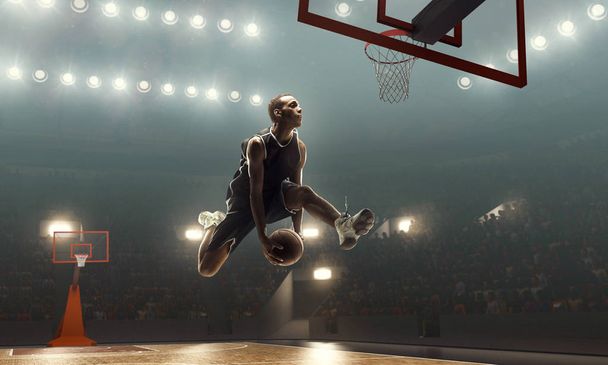Αφρικανός Αμερικανός παίκτης μπάσκετ σε δράση κοντά στο στεφάνι. Πυροβολισμός στο άλμα. Φωτισμένο γήπεδο μπάσκετ - Φωτογραφία, εικόνα
