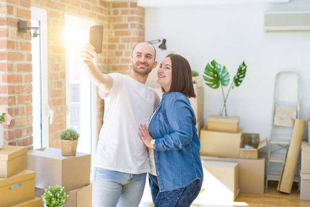 Casal jovem tirando uma foto usando smartphone em nova casa
 - Foto, Imagem