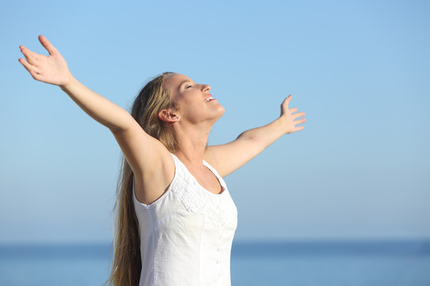 Attractive blonde woman breathing happy with raised arms - Foto, Bild